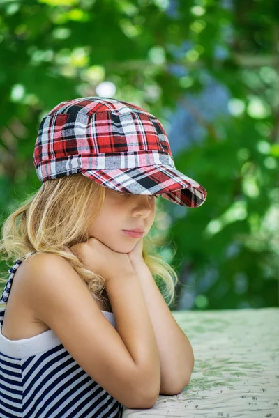 Little girl talking in plaid cap — Stock Photo, Image