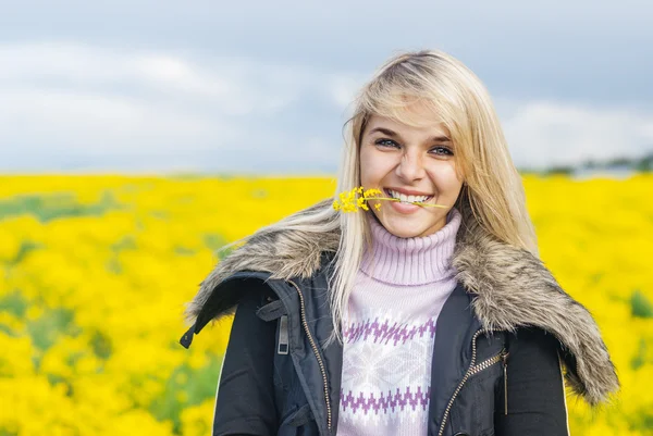 Kobieta trzyma kwiat w zęby — Zdjęcie stockowe