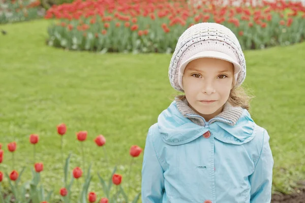 Bonita niña en el parque de tulipanes —  Fotos de Stock