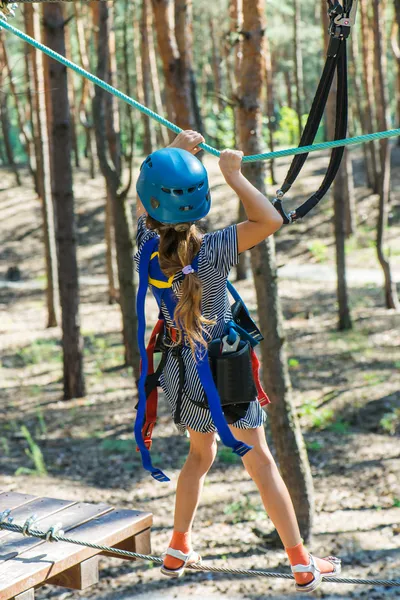 Little girl climbs on rope harness — Stock Photo, Image