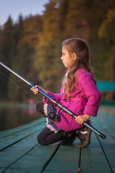 Little girl catches fishing rod — Stock Photo, Image