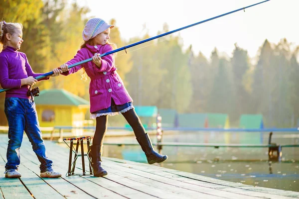 Little girls catches fishing rod — Stock Photo, Image