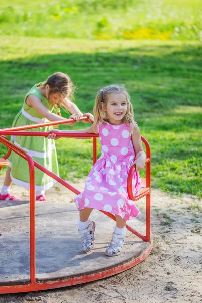 Dwie dziewczyny, kołysanie na plac zabaw dla dzieci — Zdjęcie stockowe