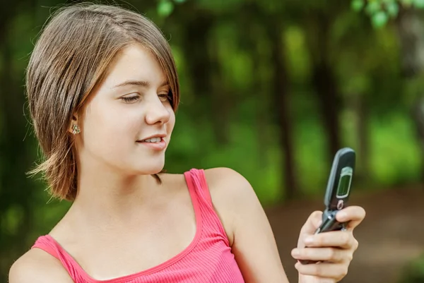 Frau liest Nachricht auf Handy vor — Stockfoto