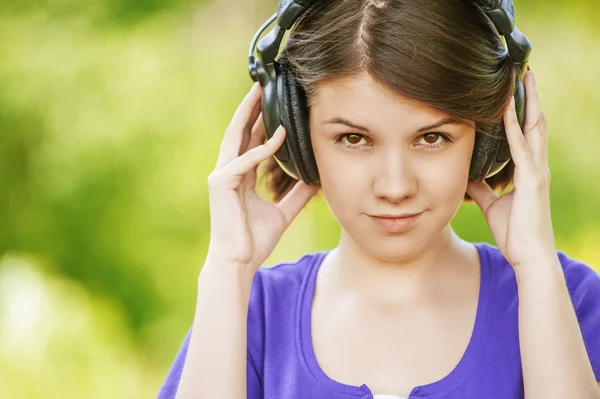 Retrato de cerca de una mujer joven con auriculares — Foto de Stock
