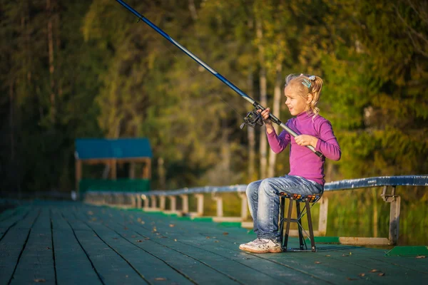 Liten flicka fångster fiskespö — Stockfoto