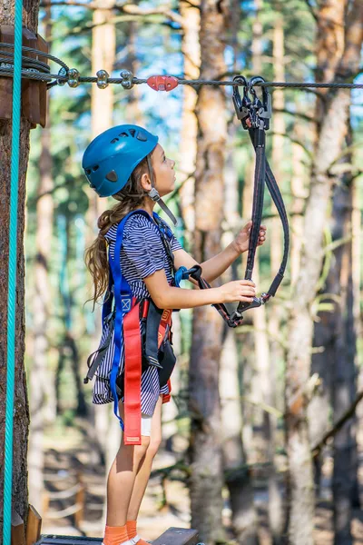 Little girl climbs on rope harness — Stock Photo, Image