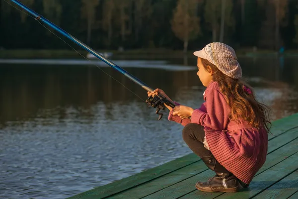 Little girl catches fishing rod — Stock Photo, Image