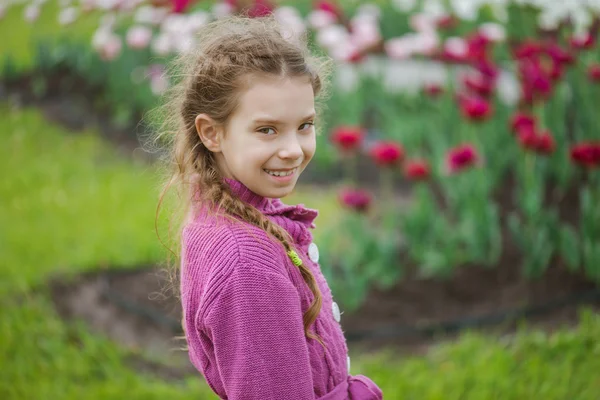 Jolie petite fille dans tulipe parc — Photo