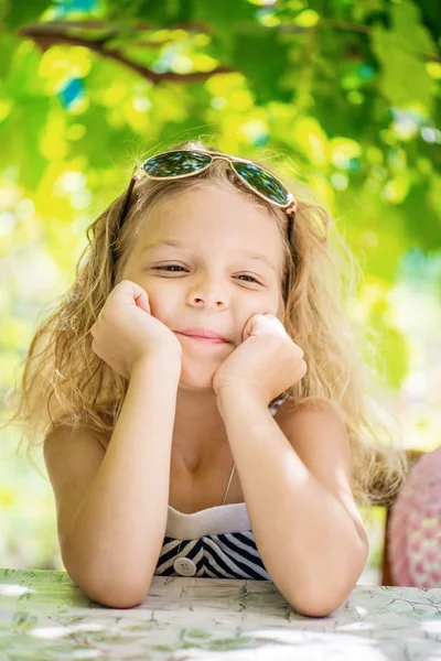 Маленькая девочка в зеленом летнем городском парке — стоковое фото