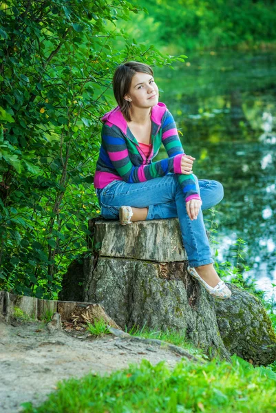Dziewczyna siedzi na stub — Zdjęcie stockowe