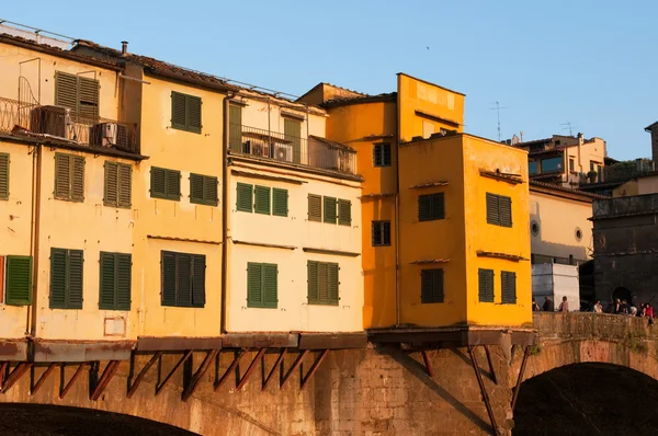 Multitud de turistas visitan el Ponte Vecchio ("Puente Viejo") que es un puente medieval sobre el río Arno en Florencia, Toscana, Italia . — Foto de Stock