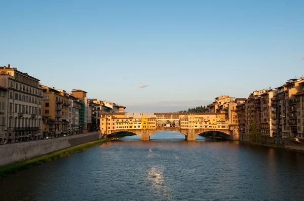 Multitud de turistas visitan el Ponte Vecchio ("Puente Viejo") que es un puente medieval sobre el río Arno en Florencia, Toscana, Italia . — Foto de Stock