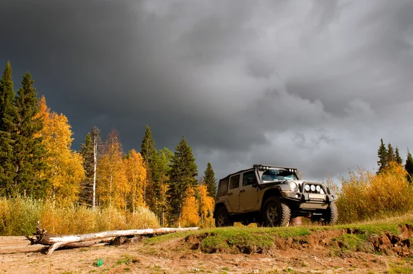 SUV na divoké horské silnici v hluboké tajgy — Stock fotografie