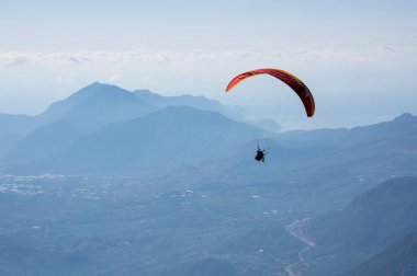 Türkiye 'nin Antalya ilinin Türk Rivierası' ndaki bir sahil beldesi olan Kemer yakınlarındaki dağların üzerinden uçan Paraglider