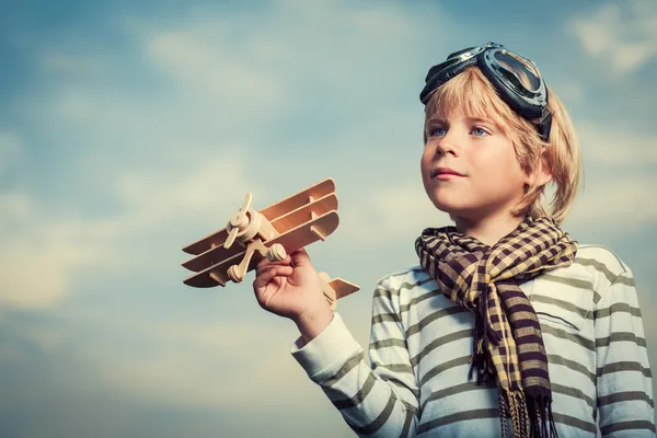 Junge mit Holzflugzeug — Stockfoto