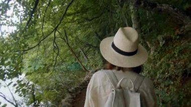 Genç turist göl boyunca yürüyor.