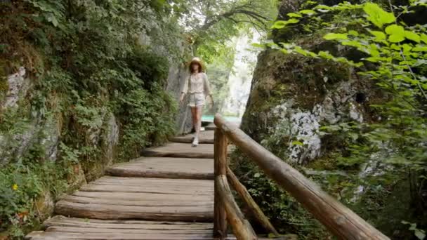 Młody podróżnik spacerujący drewnianą ścieżką w Chorwacji — Wideo stockowe