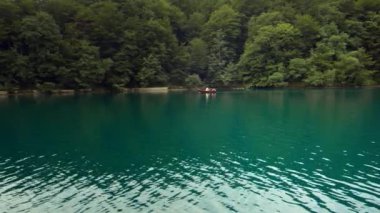 Pletvice Gölü 'nde insanlarla dolu bir tekne.