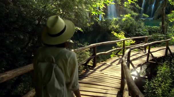 Mladý cestovatel kráčí v blízkosti vodopádů — Stock video
