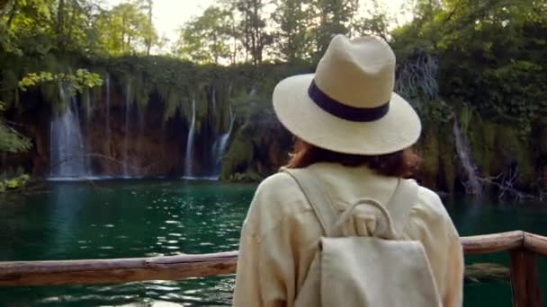 Jonge vrouw kijkt naar watervallen in Kroatië — Stockvideo