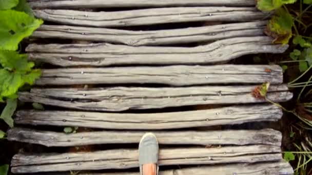 Pies masculinos caminando sobre un puente de madera, primer plano — Vídeo de stock