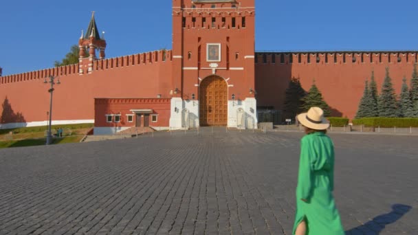 Une belle fille en robe verte aux portes de la Tour Spasskaya — Video