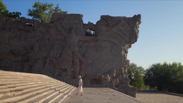 Молодой турист поднимается по ступенькам мемориального комплекса — стоковое видео