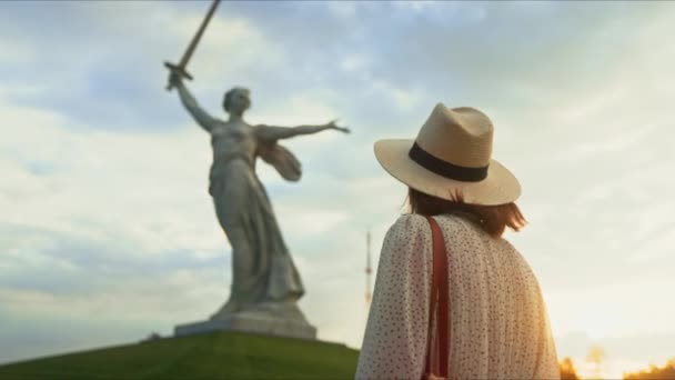 Молодая девушка в платье смотрит на Родину на Мамаевом Кургане в Волгограде — стоковое видео