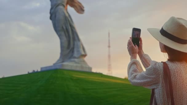 En ung turist tar ett foto av ett monument på en smartphone — Stockvideo