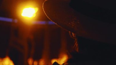 Şapkalı genç bir kız akşamları sonsuz aleve bakıyor.