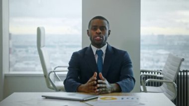 Genç Afro-Amerikalı iş adamı video ile iletişim kuruyor. Profesyonel işadamı ofisinde.