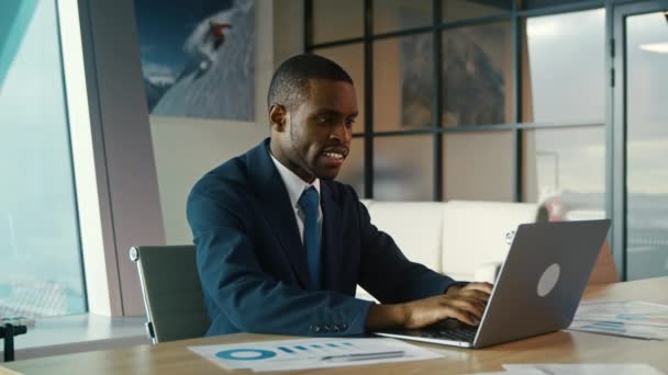 スーツを着た若い男がノートパソコンに入力する。事務所の若い実業家 — ストック動画