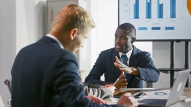 Genç bir lider iş arkadaşlarına şirketin kâr analizini açıklıyor. Teknolojiyi kullanan iş adamları