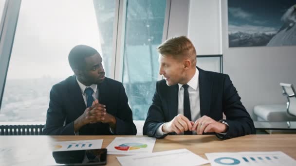 Hombres colegas discutiendo un nuevo proyecto en la oficina. Dos hombres de negocios en una reunión en un coworking — Vídeos de Stock