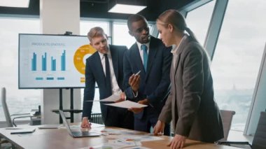 Gençler ofiste soruları tartışıyor ve kurumsal verileri analiz ediyorlar.