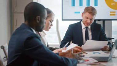 İş adamları ofiste soruları tartışıyor ve kurumsal verileri analiz ediyorlar.