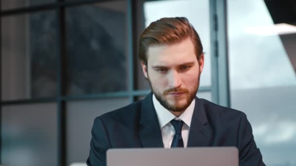 Joven navegando por Internet usando un portátil. Joven hombre de negocios con portátil — Vídeos de Stock