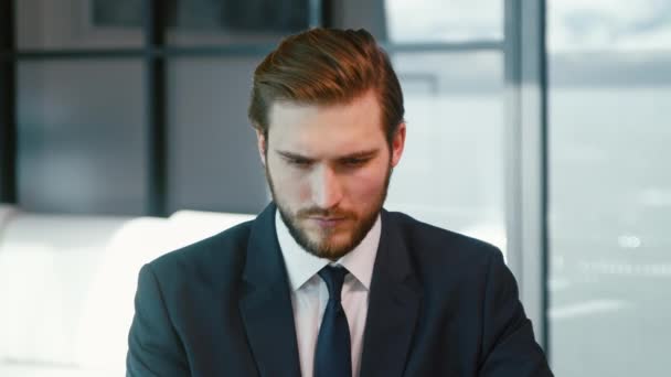 Hombre serio navegando por Internet usando un portátil. Joven hombre de negocios con portátil — Vídeos de Stock