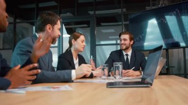 Gülümseyen iş analistleri ofiste bir projeyi tartışıyorlar.