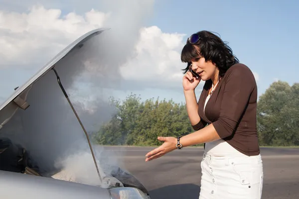 Woman near smoking car calling for help — Stock Photo, Image