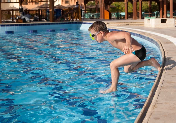 Menino pulando na piscina — Fotografia de Stock