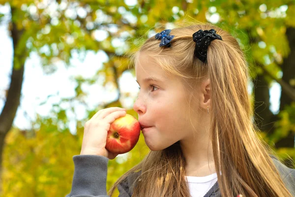 Malá dívka jíst jablko — Stock fotografie