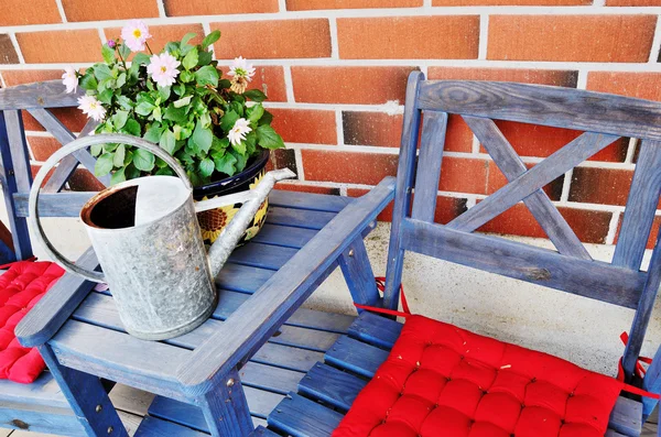 Watering can and flower pot on the table — Stock Photo, Image