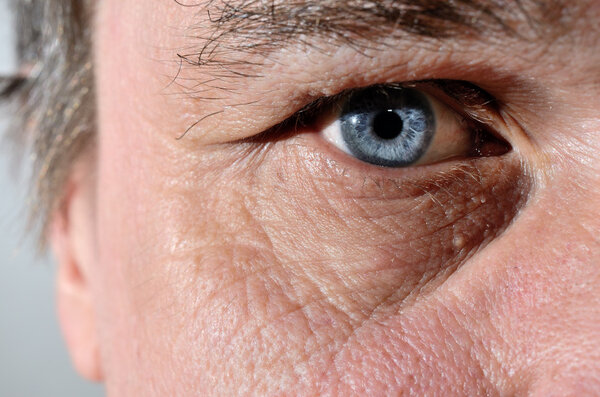part of a seniors face with blue eye