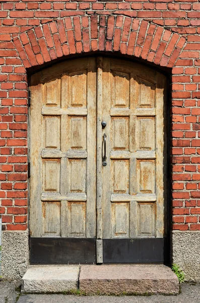 Gran puerta amarilla en la pared de ladrillo — Foto de Stock