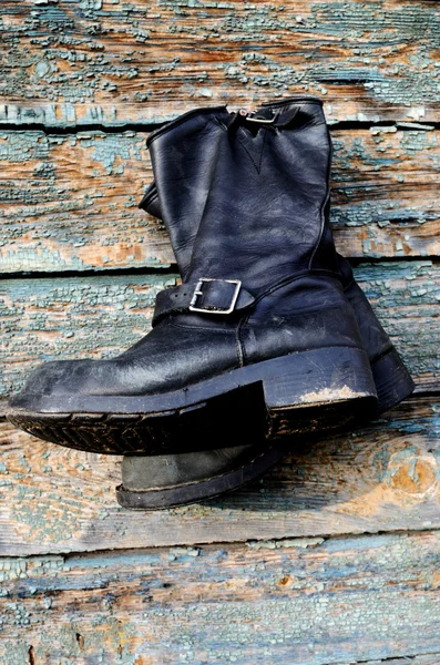 Old vintage leather boots hang on the wall — Stock Photo, Image