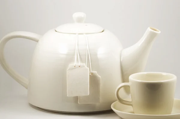 Taza de té blanca y tetera con dos etiquetas en blanco — Foto de Stock