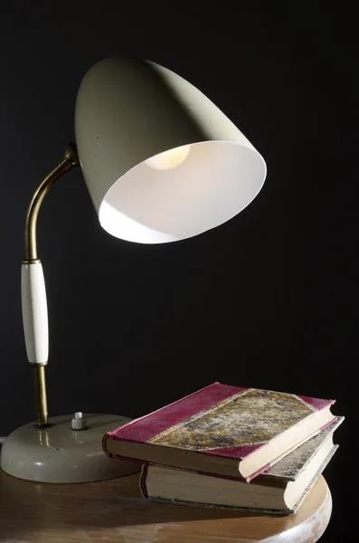 Старинная настольная лампа и несколько книг — стоковое фото