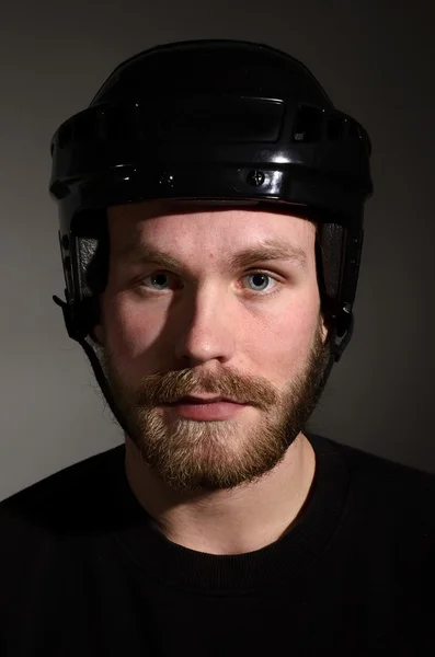 Portret van een jonge man met baard in hockey helm — Stockfoto